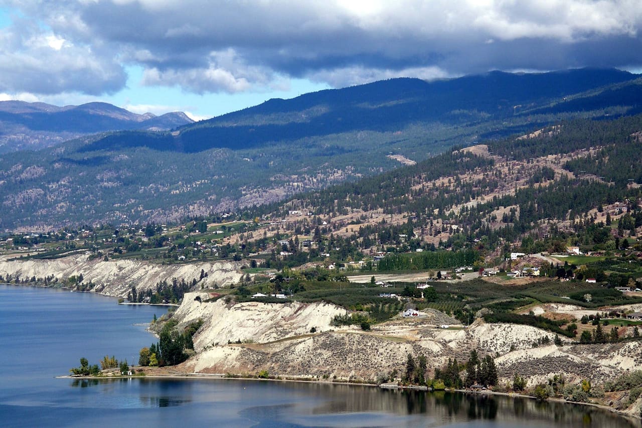 The Naramata Bench above Okanagan Lake, with pale silt cliffs along the shore and vineyards on the slopes behind.